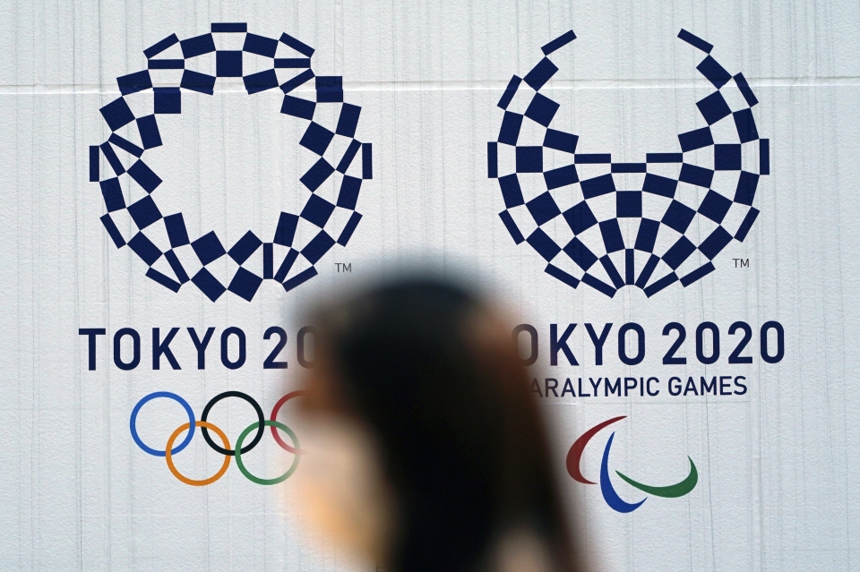 2일 일본 도쿄에서 신종 코로나바이러스 감염증(코로나19) 예방을 위해 마스크를 쓴 한 여성이 연기된 도쿄 올림픽·패럴림픽 조형물 앞을 지나가고 있다. 일본 코로나19 누적 확진자는 1일 기준 하루 새 266명 늘어 3207명, 사망자는 3명 증가한 80명으로 집계됐다.ⓒap
