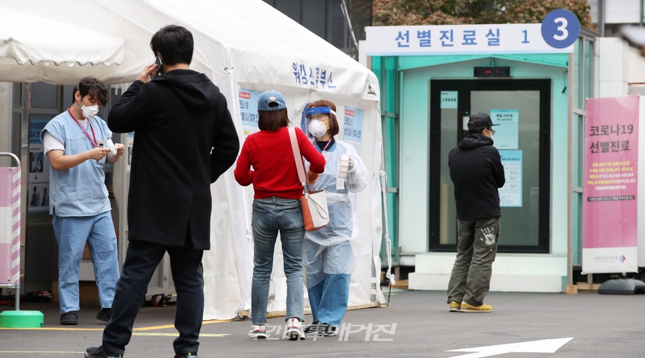 의료진이 16일 오후 서울 중구 국립중앙의료원에 마련된 선별진료소에서 내원객들에게 코로나19 검사 안내를 하고 있다.