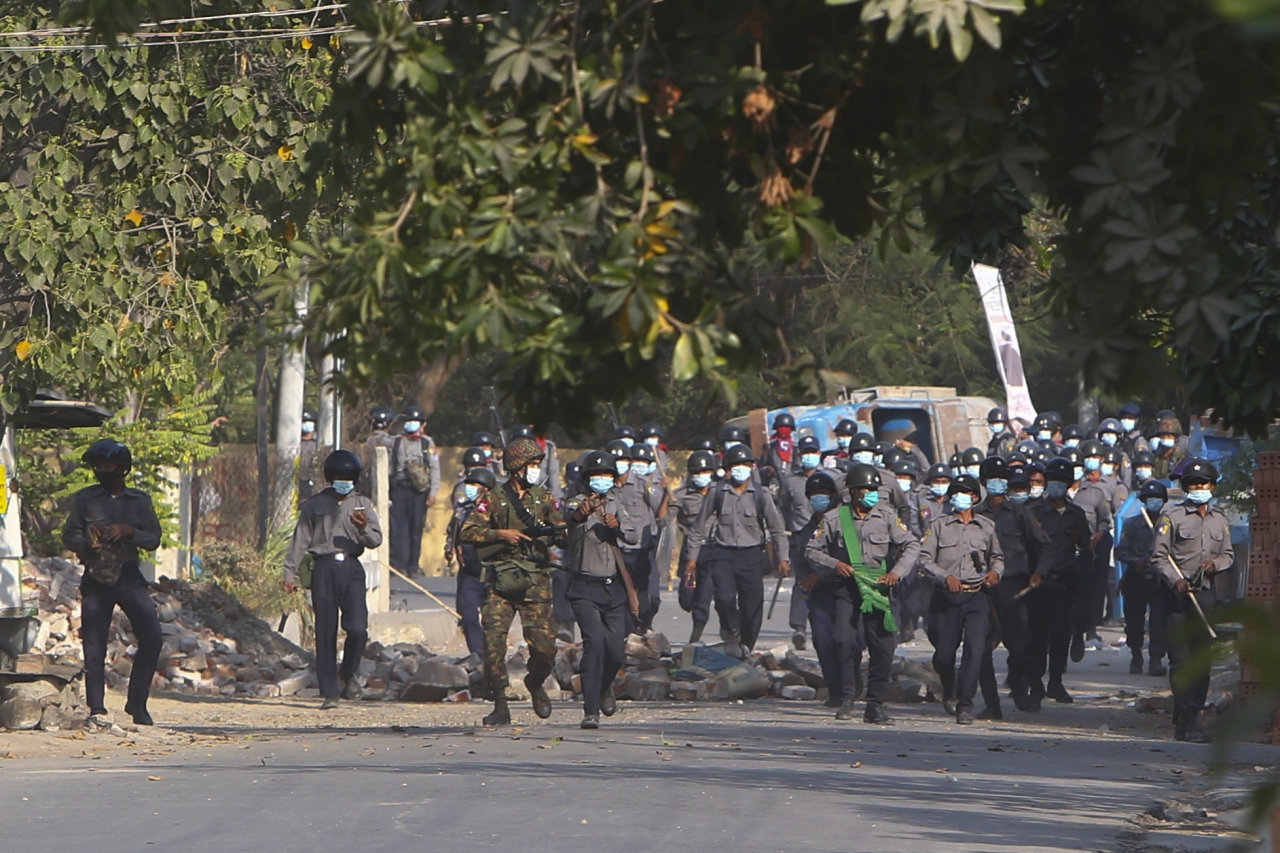 미얀마 군경이 28일(현지시간) 미얀마 제2의 도시 만달레이에서 반쿠데타 시위대를 진압하기 위해 봉쇄선을 넘고 있다. 이날 군경의 무력 진압으로 최소 18명의 시위대가 사망하고 수십명이 다쳤다.ⓒap